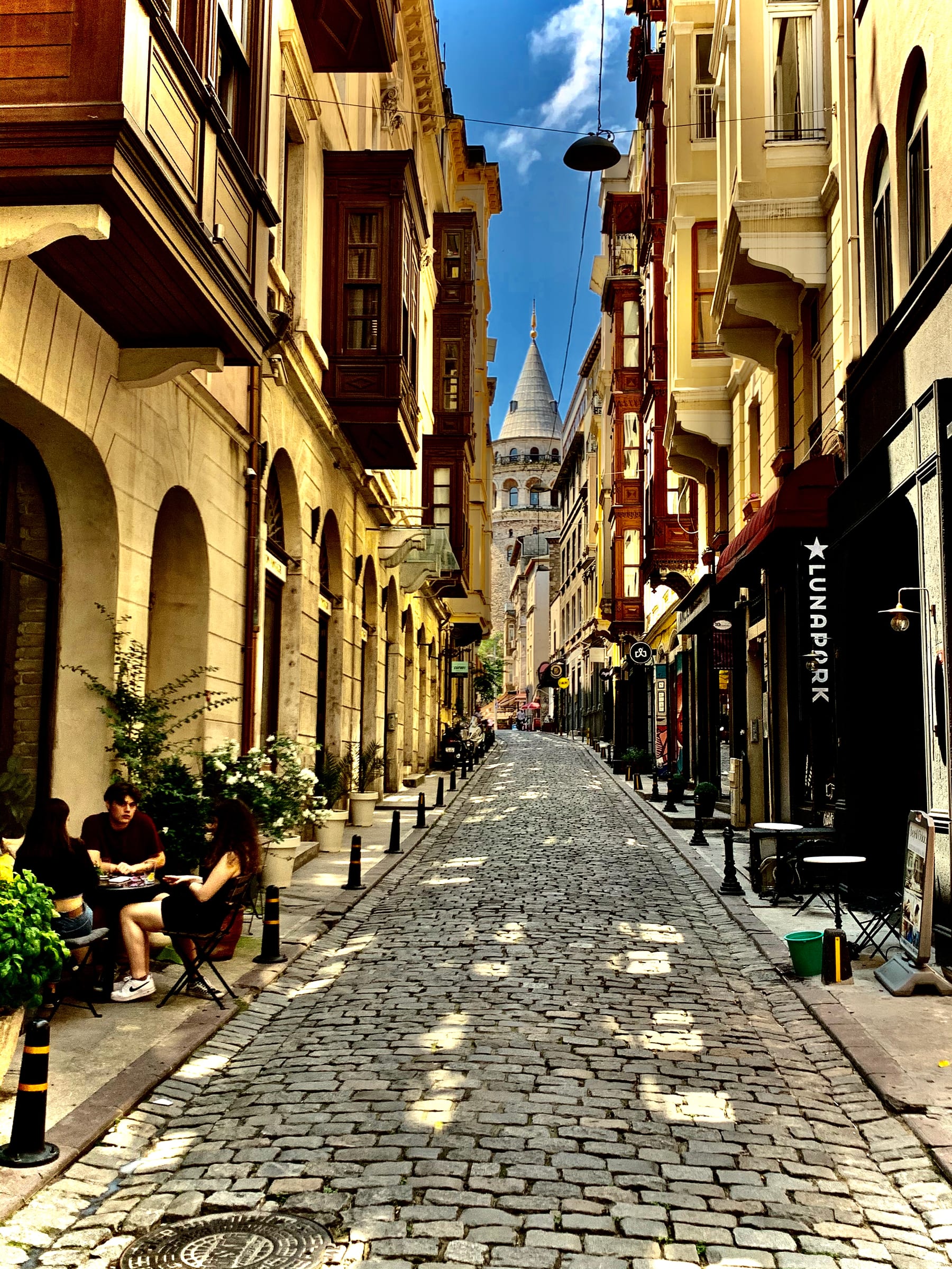 A quiet cobbled Istanbul side street leading up toward the Galata Tower
