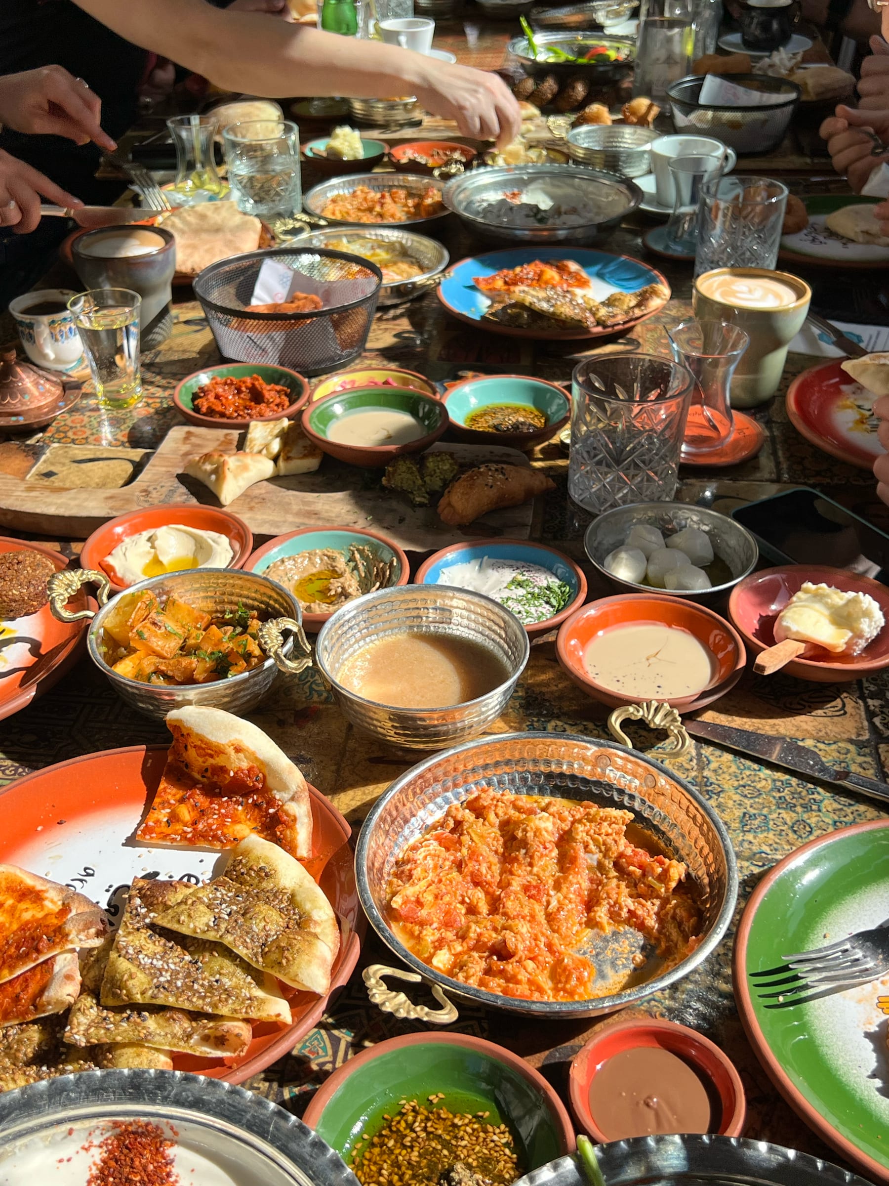 An overhead spread of Turkish meze, dips and small plates on a rustic table