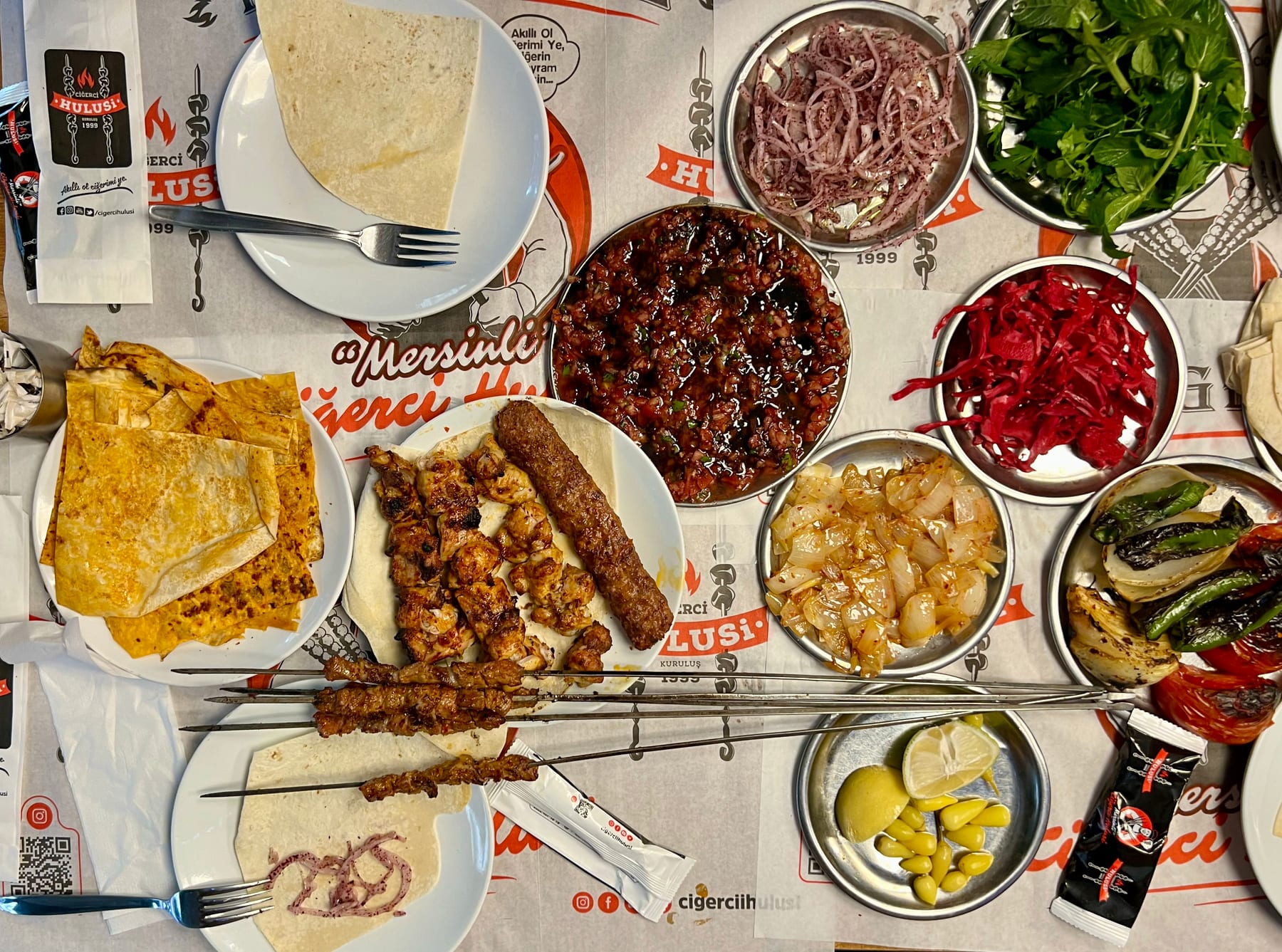 A colourful spread of Turkish kebabs, mezes and pickles on a table