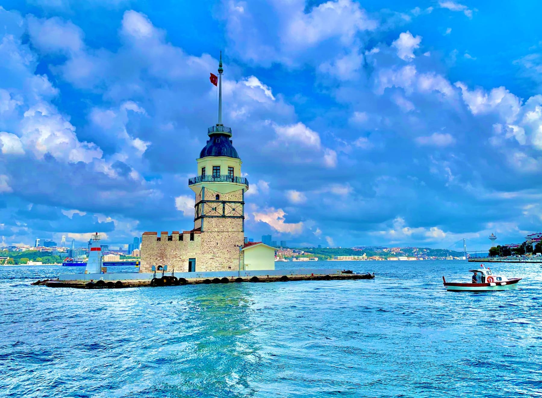 The Maiden’s Tower (Kiz Kulesi) standing on its islet in the Bosphorus as a small boat passes by